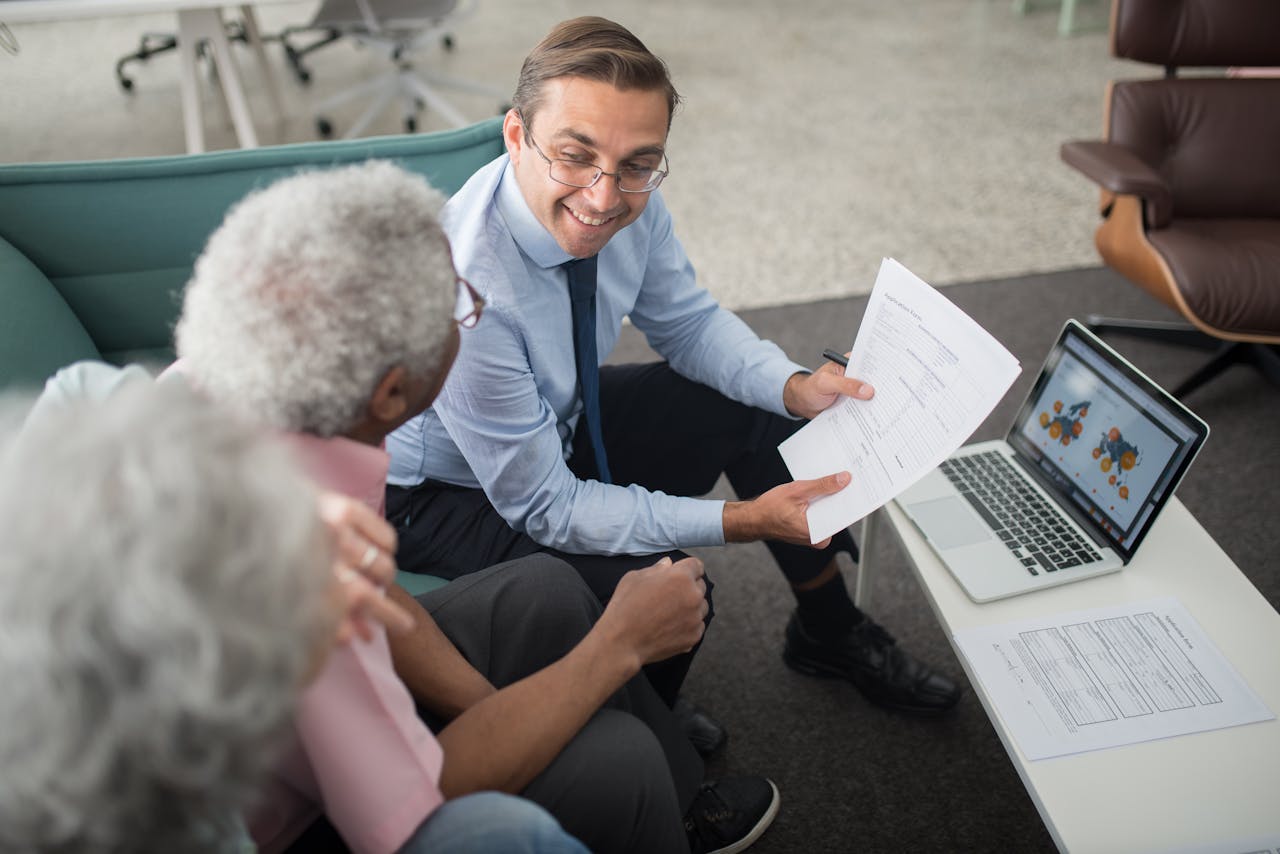 home-hero Financial advisor discussing documents with senior clients in an office setting, showcasing a collaborative consulting session.