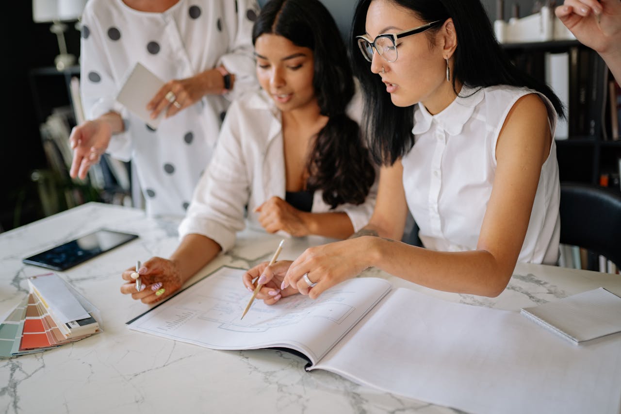 about-us Professional women discussing project details during a collaborative office meeting.